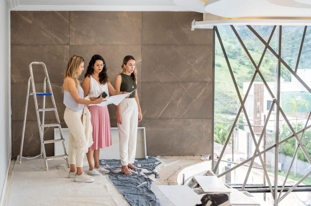 Interior designer vs interior decorator. Interior designers reviewing architectural plans during a luxury residential renovation, illustrating the complexity of the interior design process involving construction coordination, materials, spatial planning, and project management